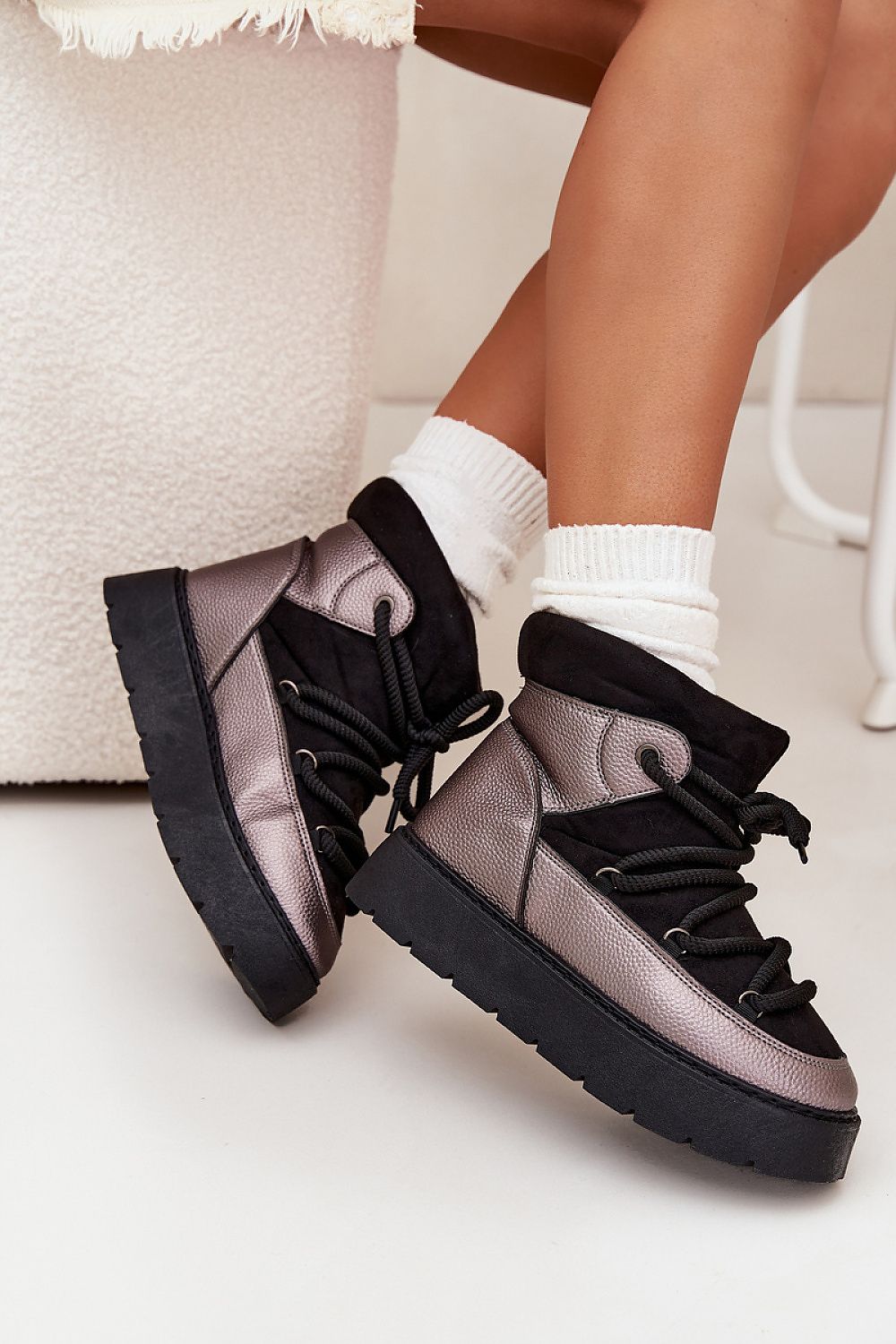 Side view of black eco suede and eco leather snow boots on a platform sole
