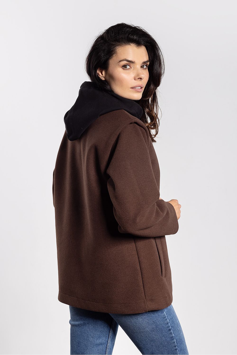 Woman wearing a brown coat with a hood on a white background