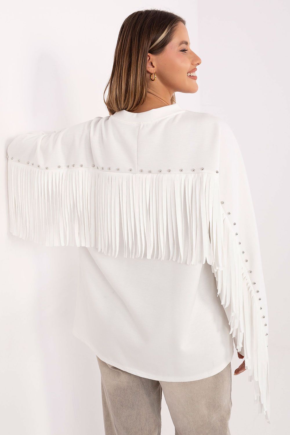 Back of white sweatshirt with flowing fringes and studded details