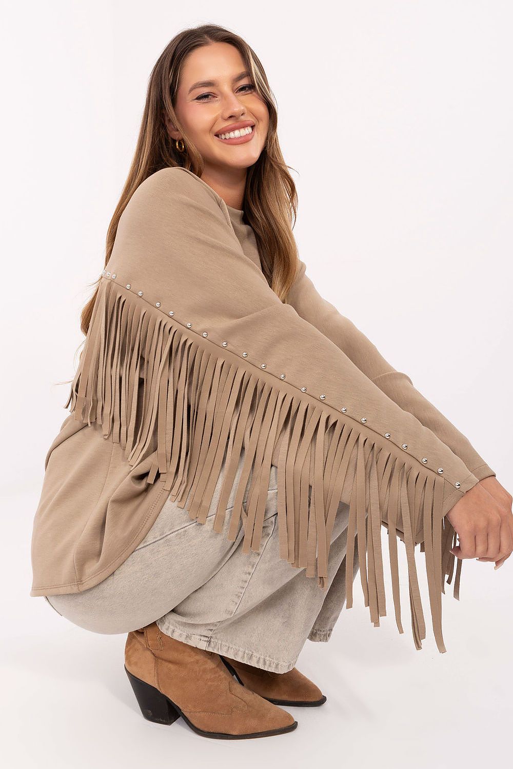 Detailed shot of beige sweatshirt’s studded fringes on sleeves