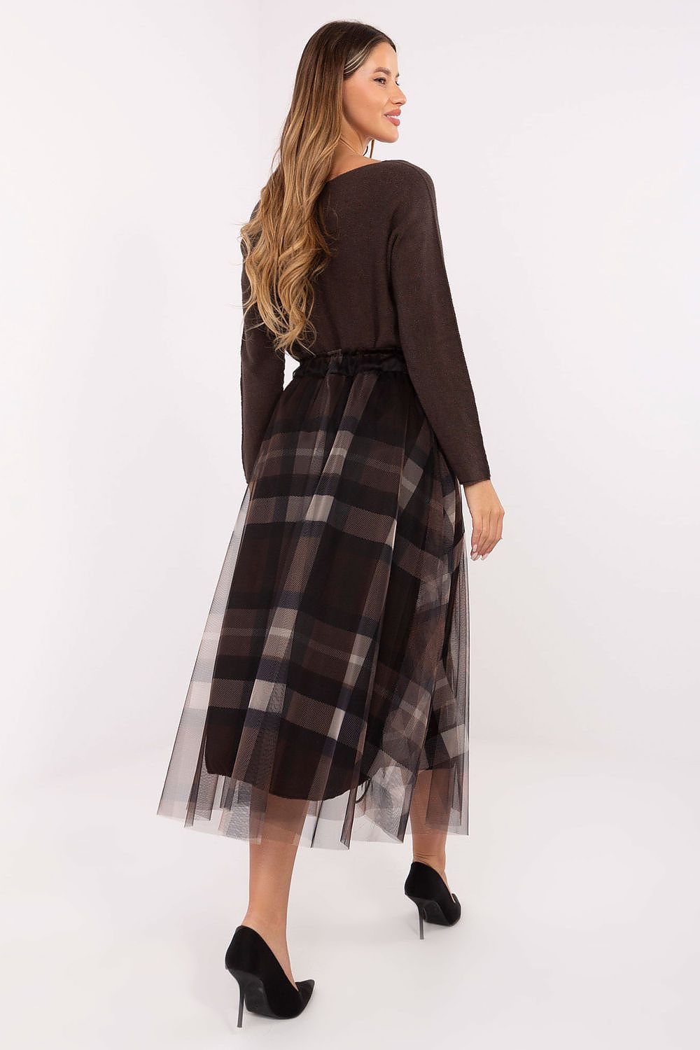 Close-up of checkered pattern and delicate tulle overlay on elegant midi skirt. 