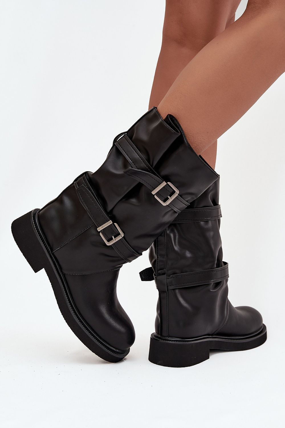 Side view of slip-on eco leather boots showing flat heel and decorative buckles.