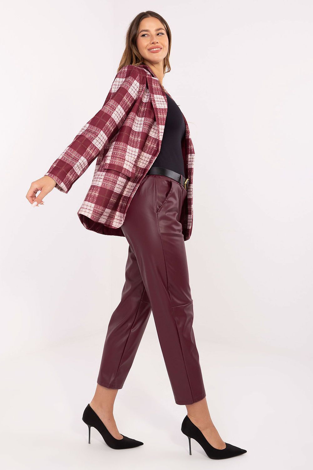 Red tapered faux leather trousers showcasing sleek silhouette – side view.