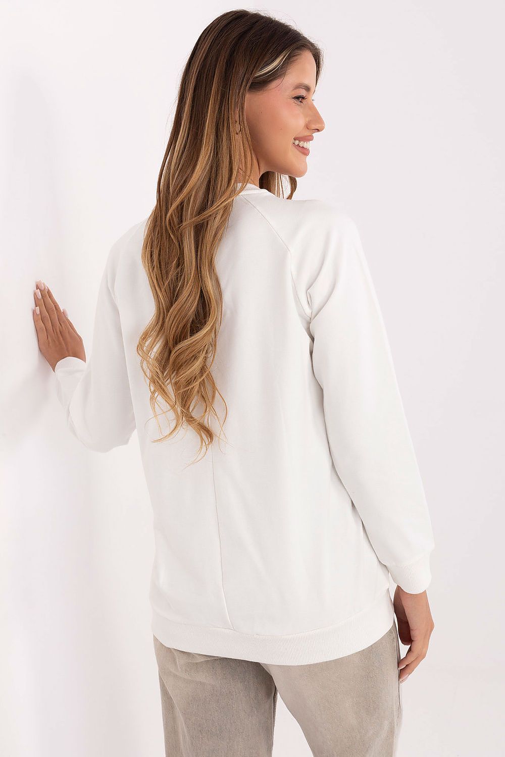  Model wearing beige sweatshirt highlighting soft fabric and delicate embroidery