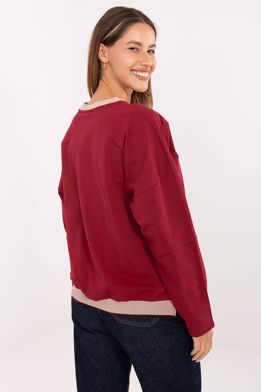 Woman wearing a red sweater with a plain white background