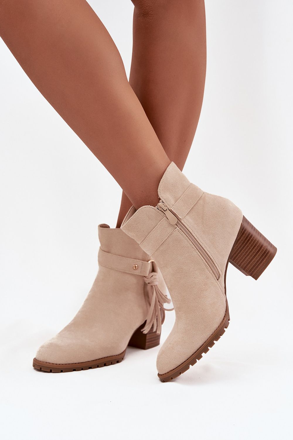 Close-up of beige fringe strap detail on eco-suede ankle boots