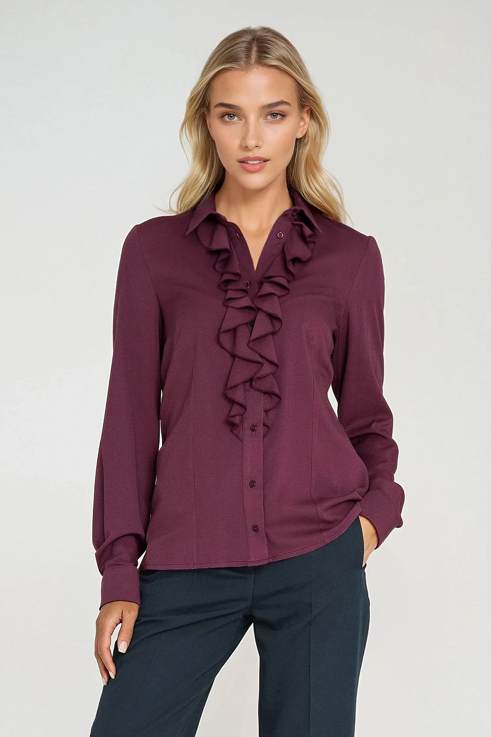 Woman wearing a purple blouse with ruffled details on a white background