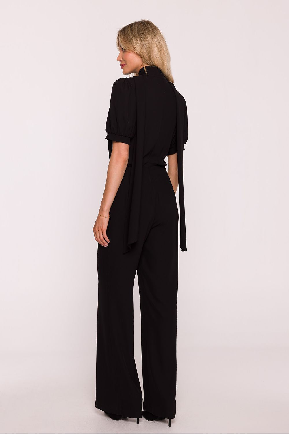 Woman wearing a black jumpsuit on a white background