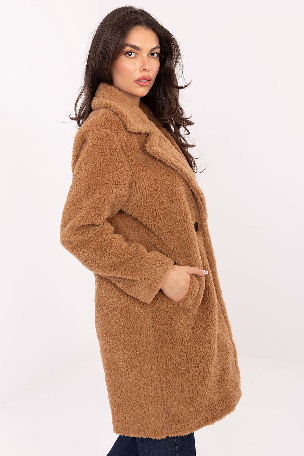 Woman wearing a brown teddy coat on a white background