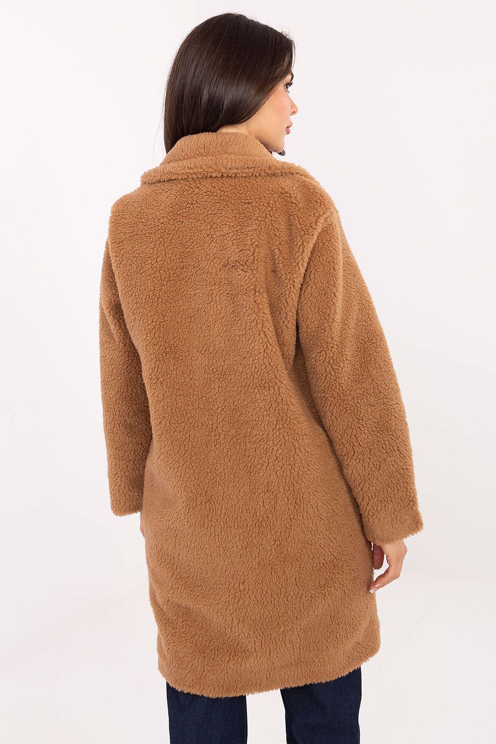Woman wearing a brown teddy coat on a white background