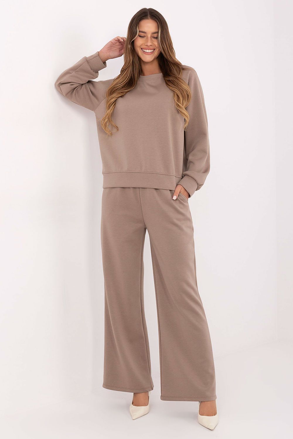 Woman wearing a brown tracksuit against a white background