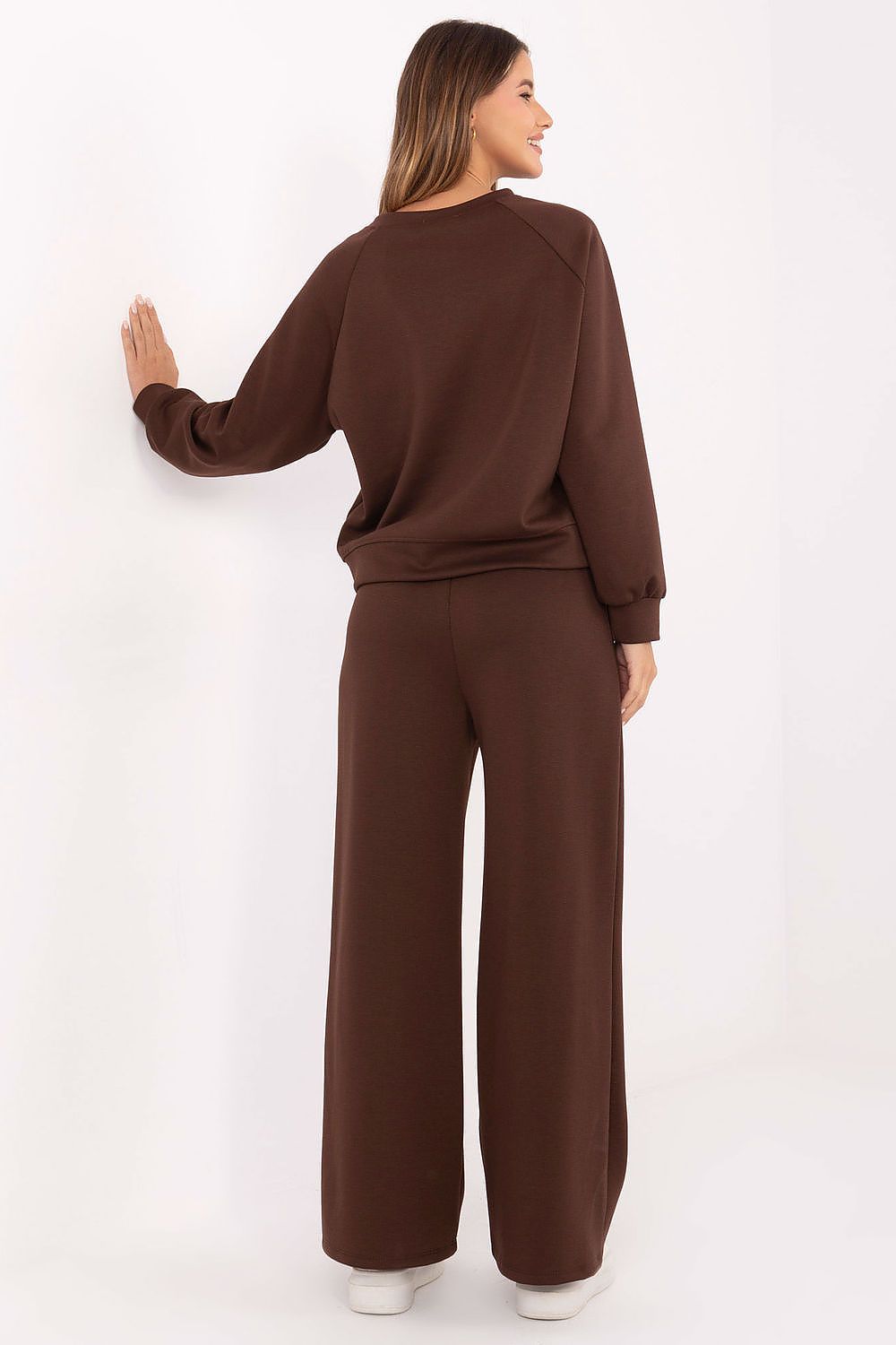 Woman wearing a brown outfit against a white background