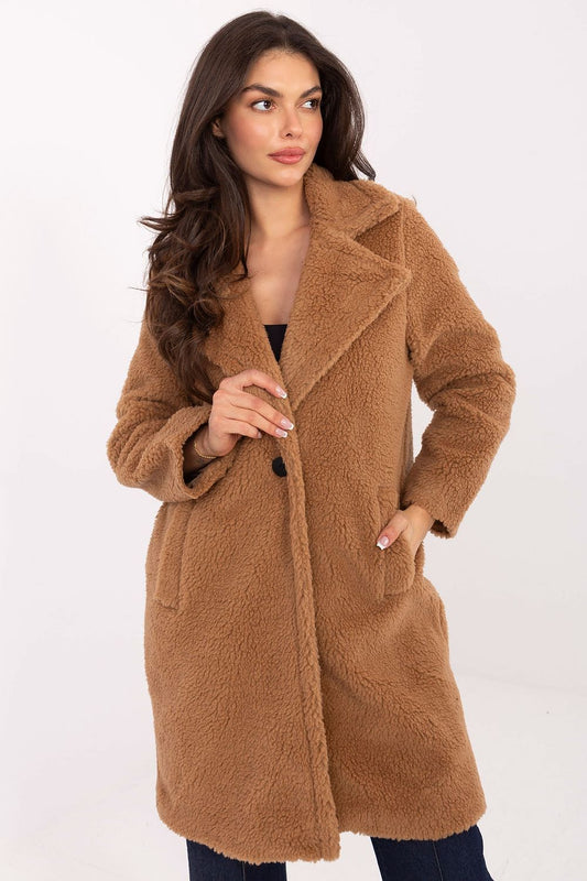 Woman wearing a brown teddy coat on a white background
