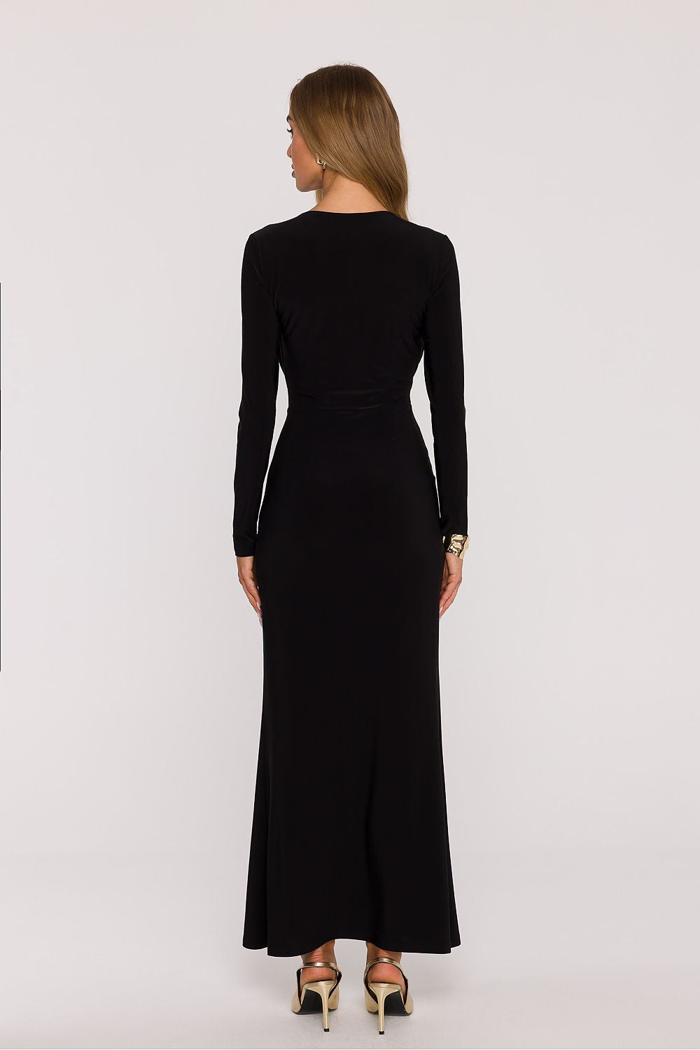 Woman wearing a black long-sleeve dress on a white background