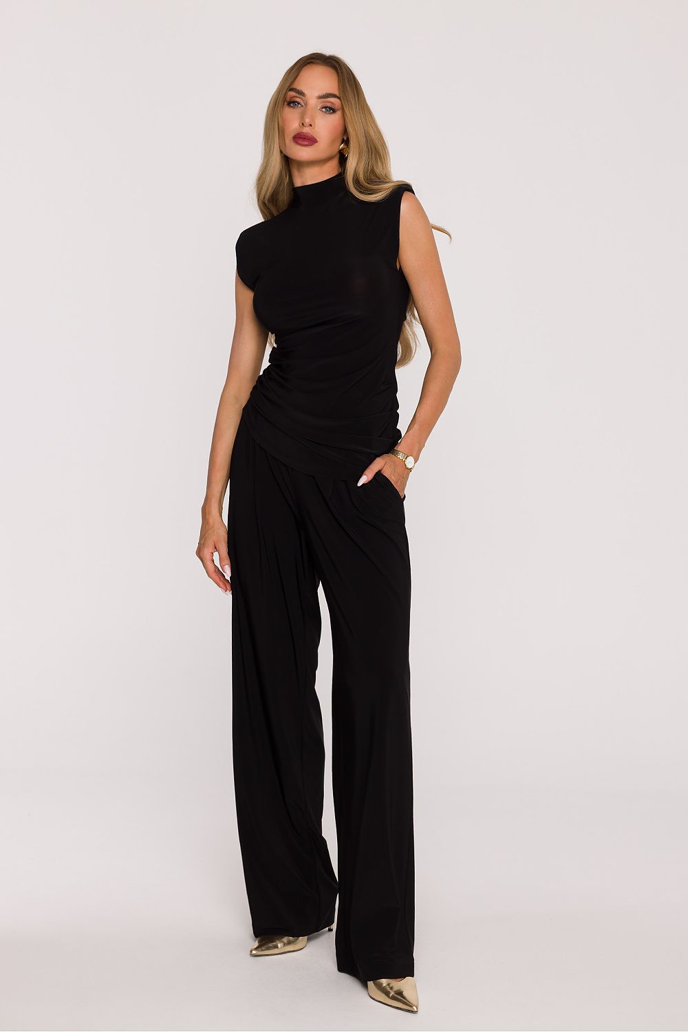 Woman wearing a black jumpsuit on a white background