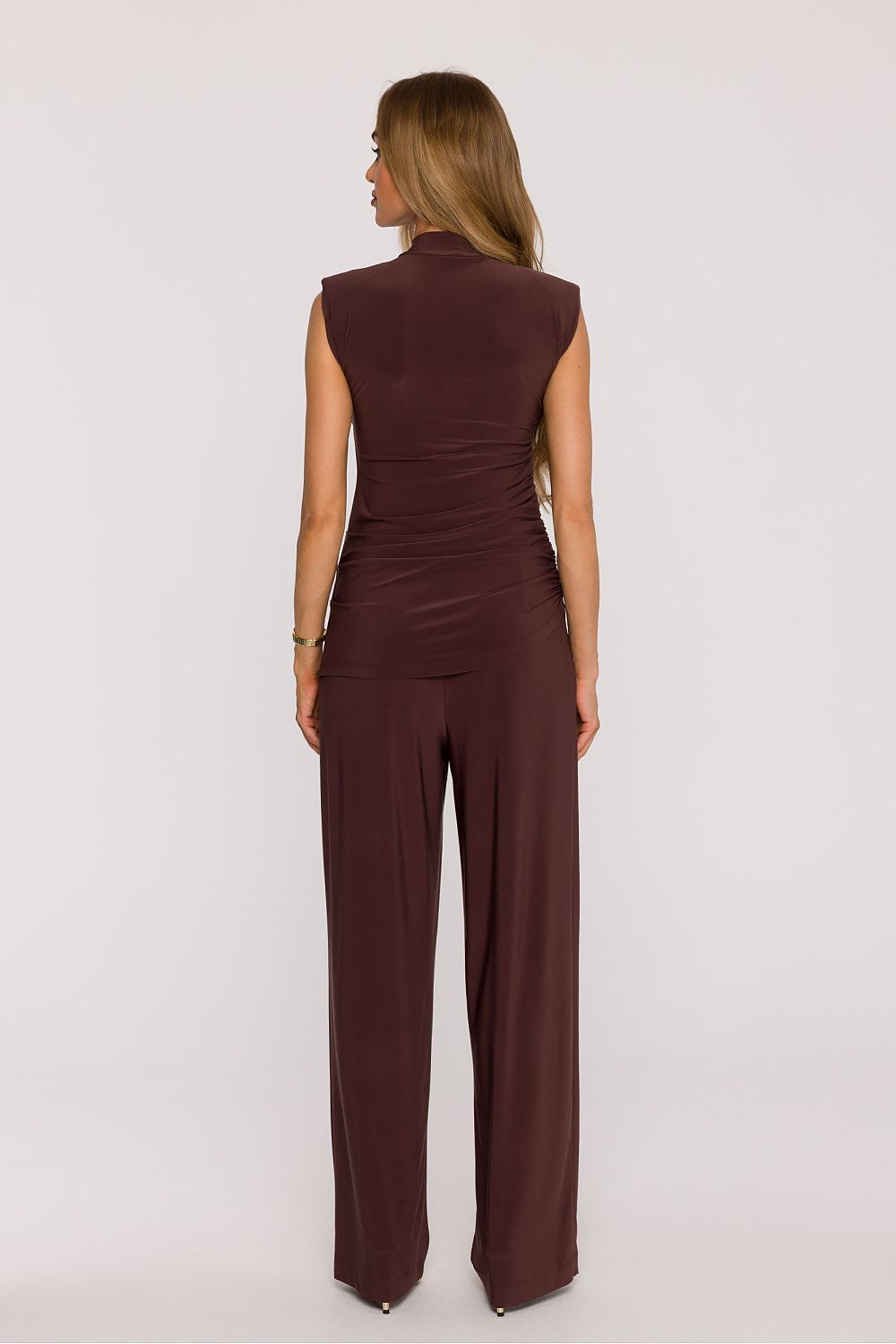 Woman wearing a brown jumpsuit on a white background