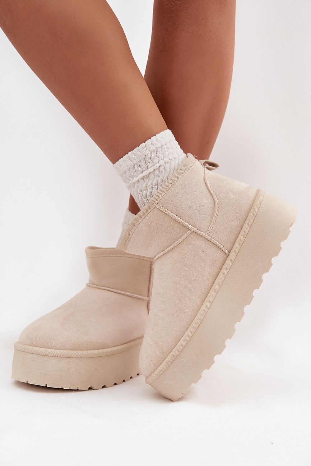 Side view of warm faux suede women’s snow boots showing soft fur interior and button detail.