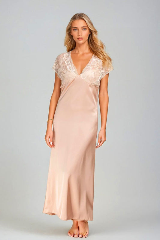 Woman wearing a lace top and satin skirt set against a plain background