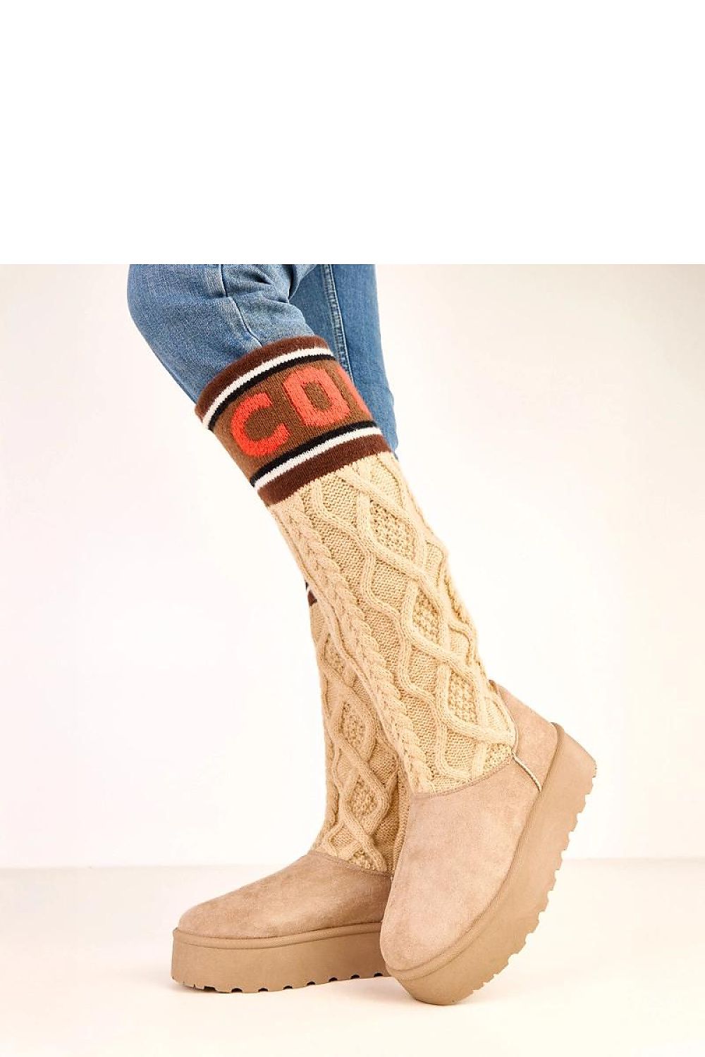 Beige platform boots with a patterned sock and blue jeans on a white background