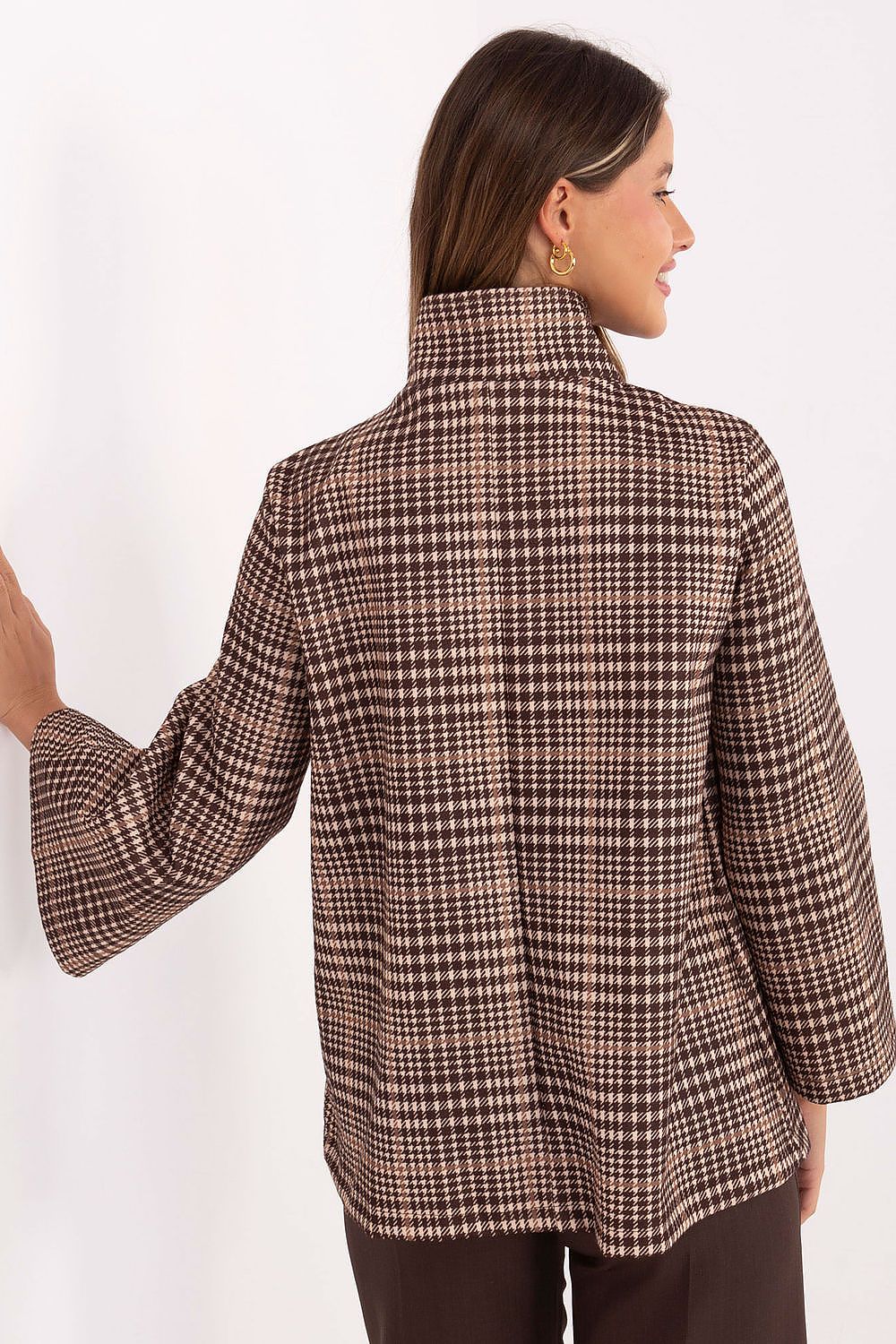 Woman wearing a brown checkered jacket on a white background