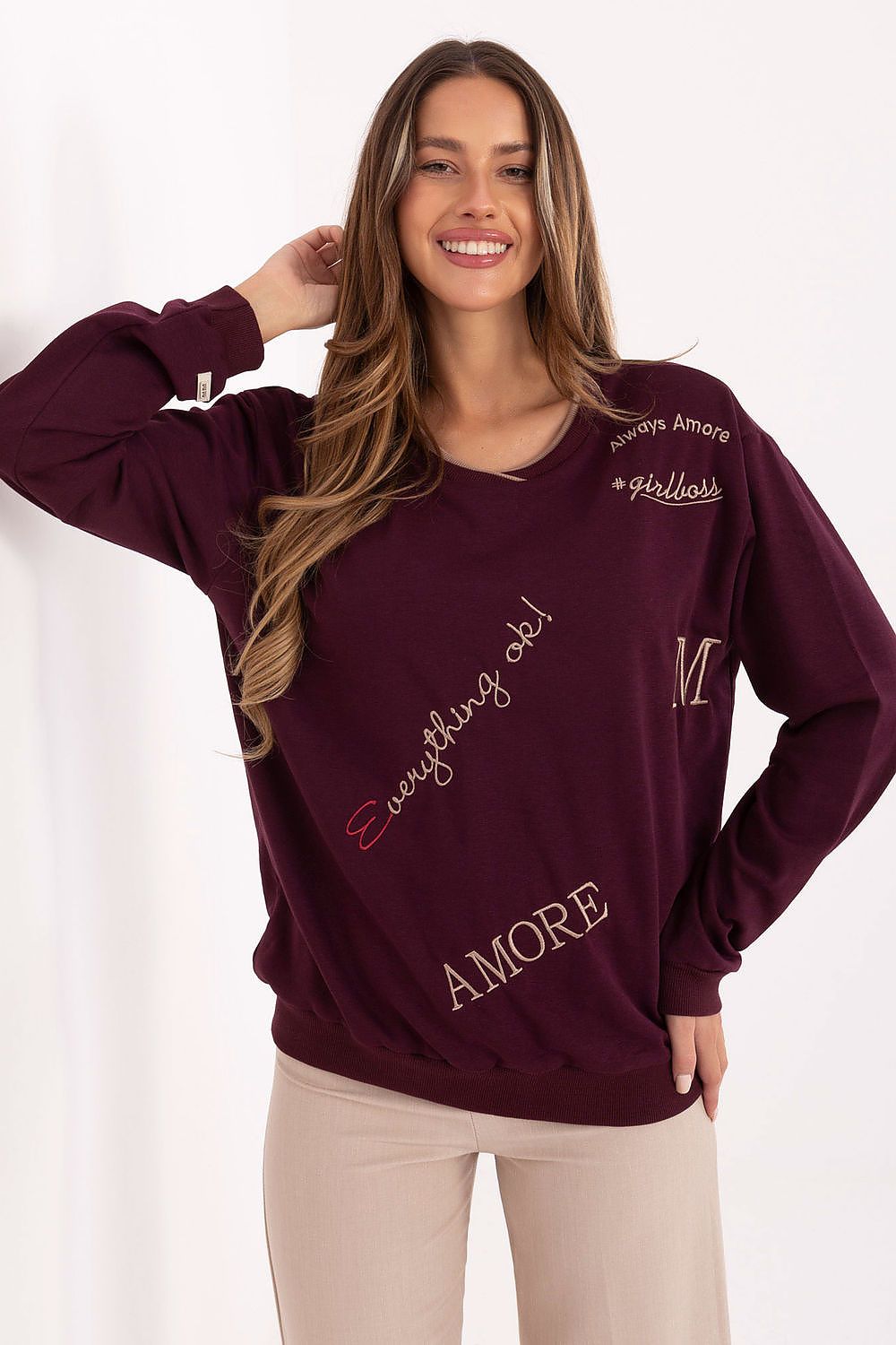 Woman wearing a burgundy sweatshirt with text on a white background