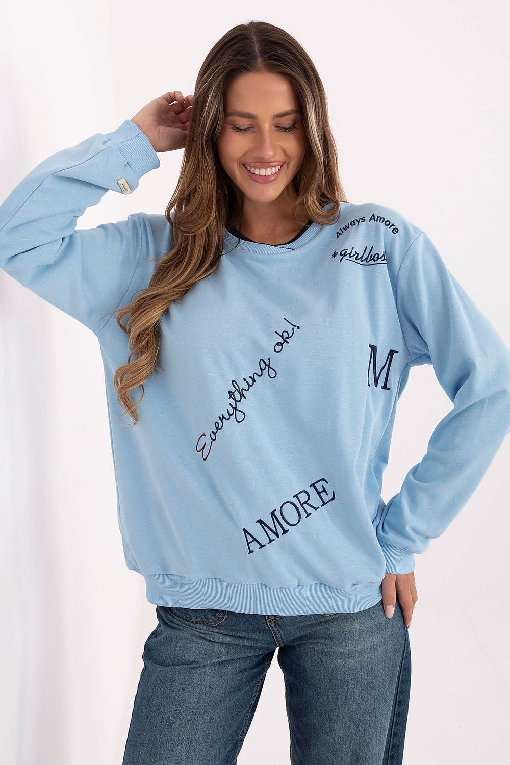 Woman wearing a light blue sweatshirt with text on a white background