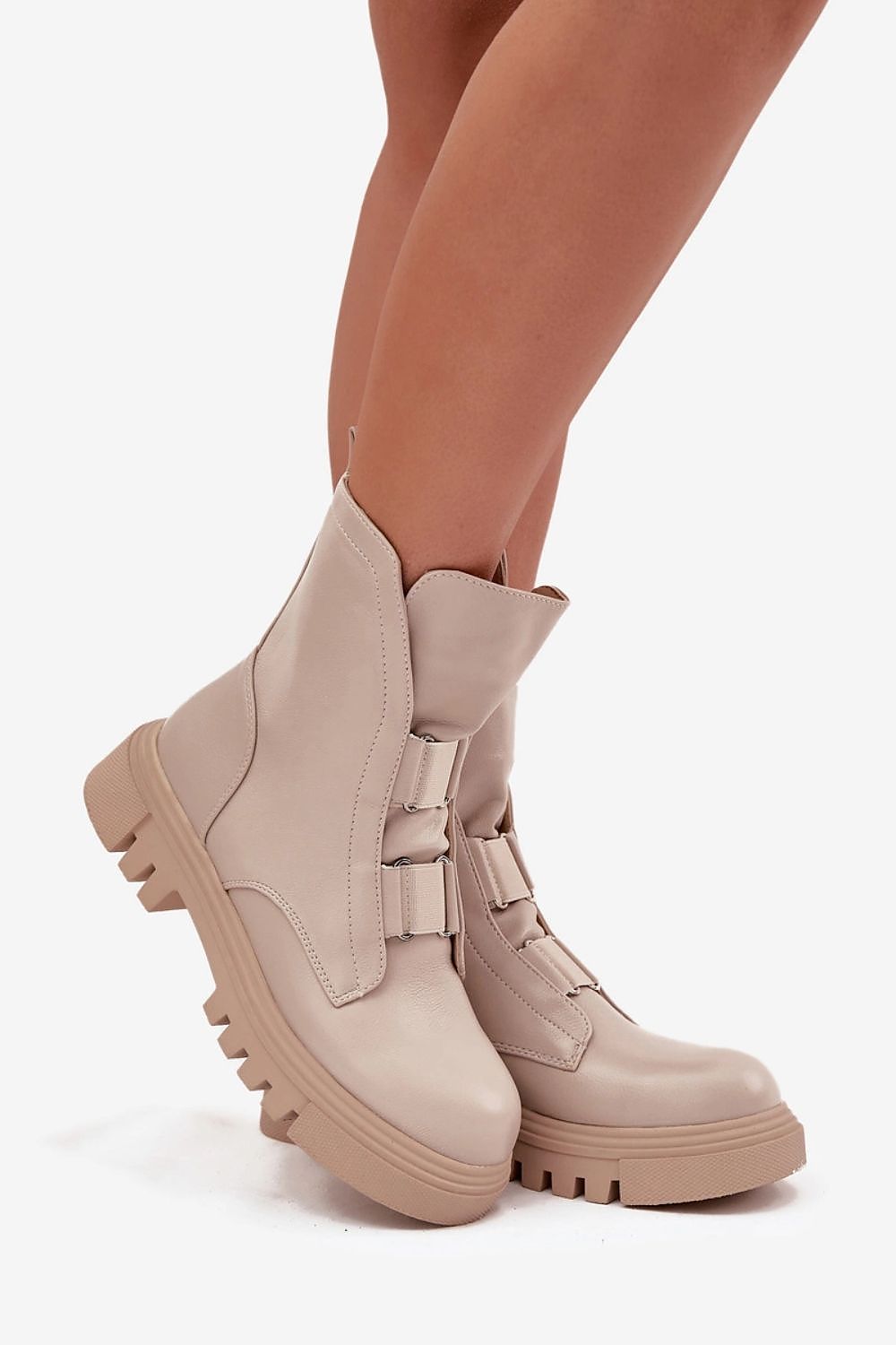 Beige boots worn by a person on a white background