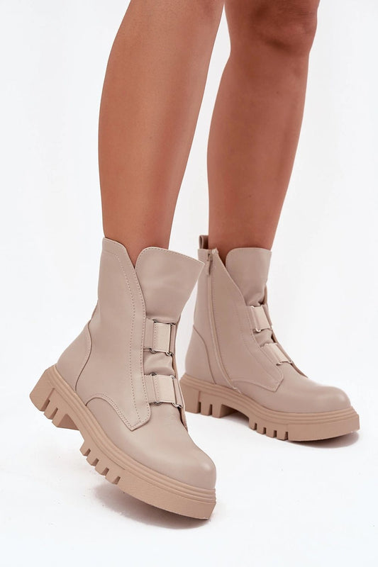 Beige boots worn with beige leggings on a white background