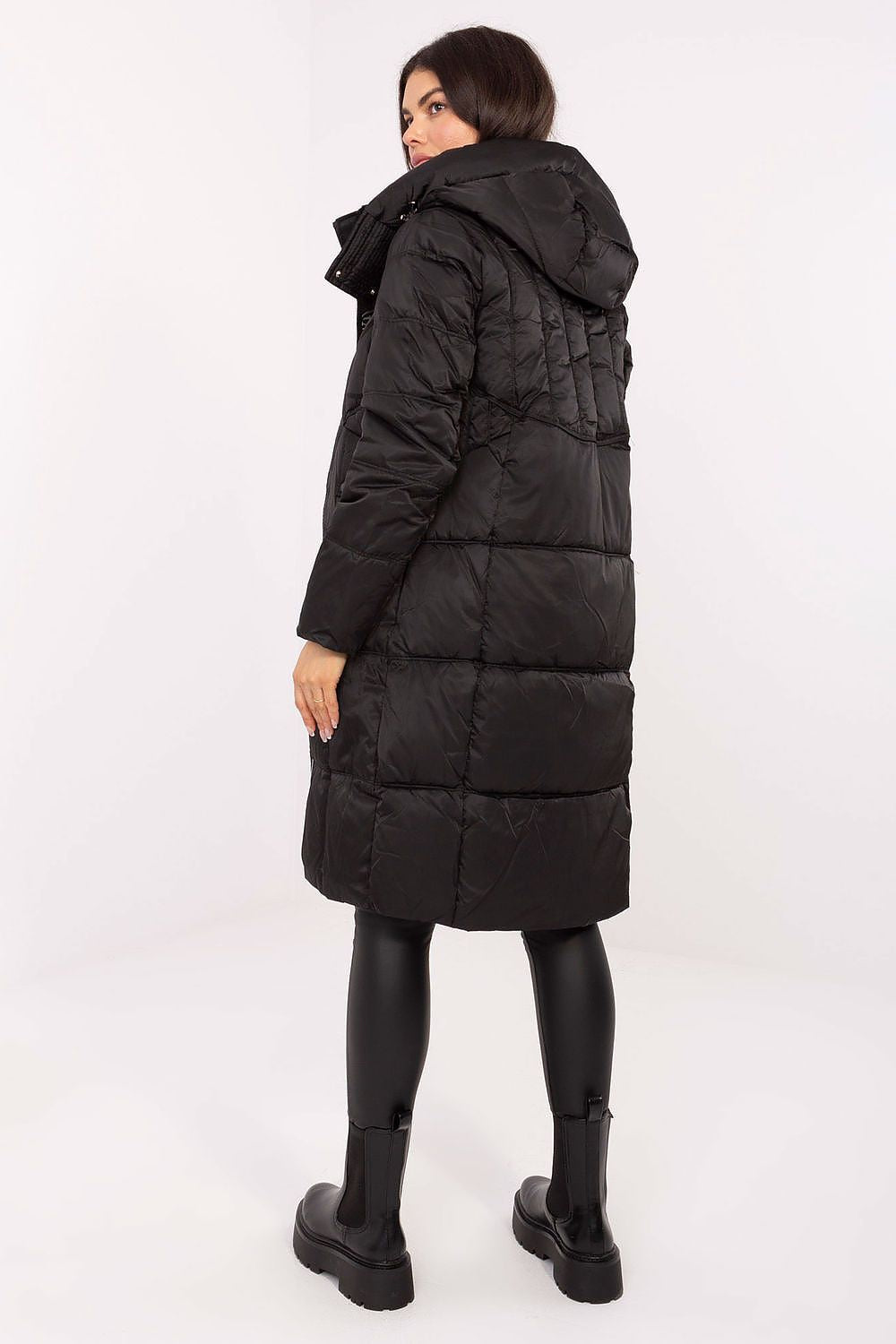 Person wearing a black puffer coat on a white background