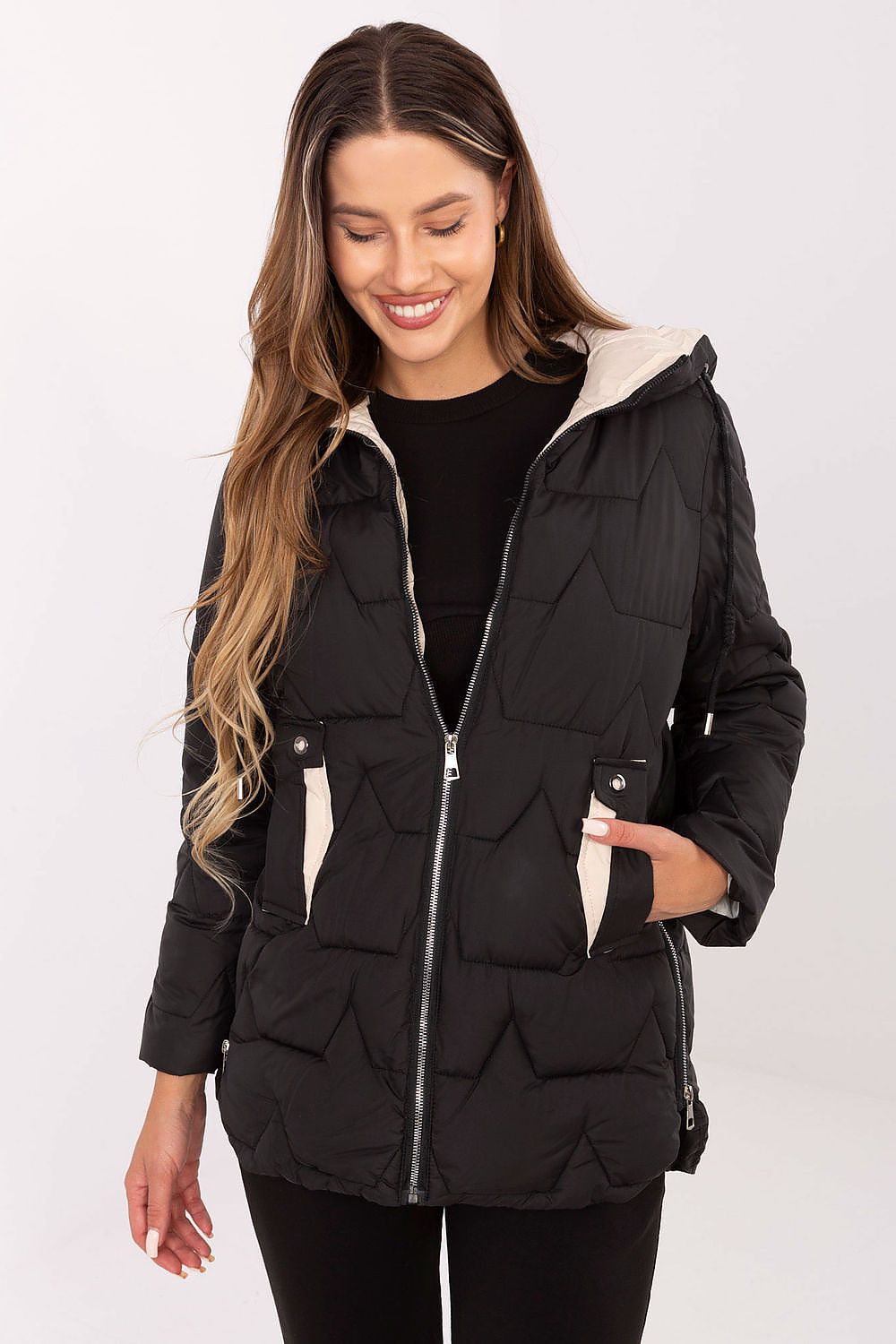 Woman wearing a black puffer vest with a white background
