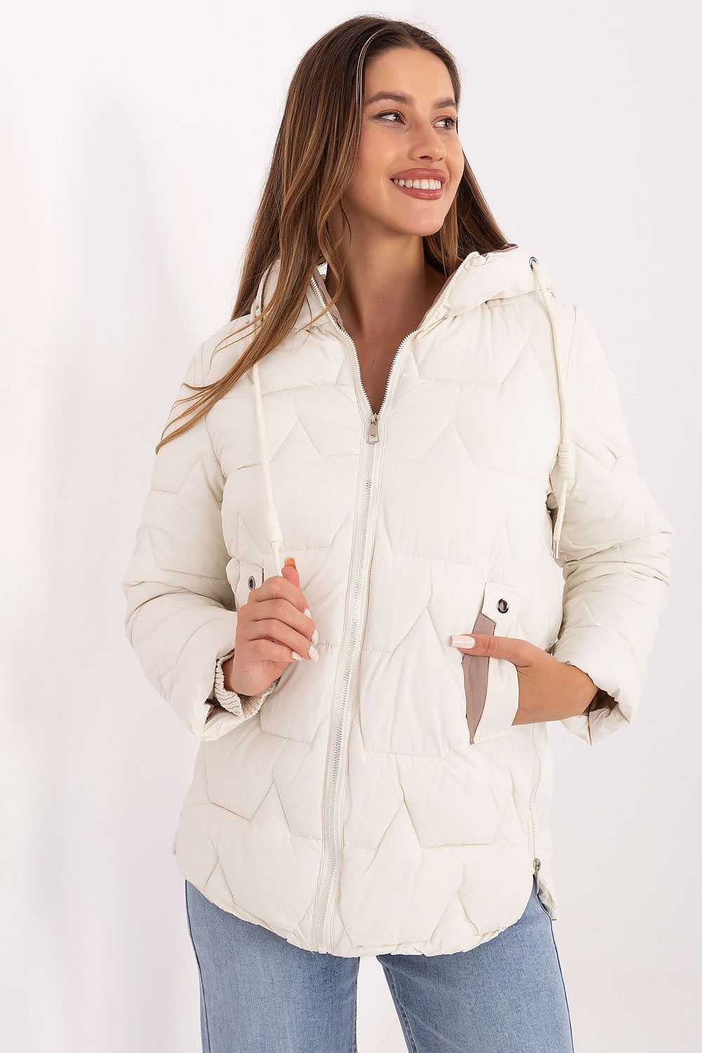 Woman wearing a white quilted jacket against a white background