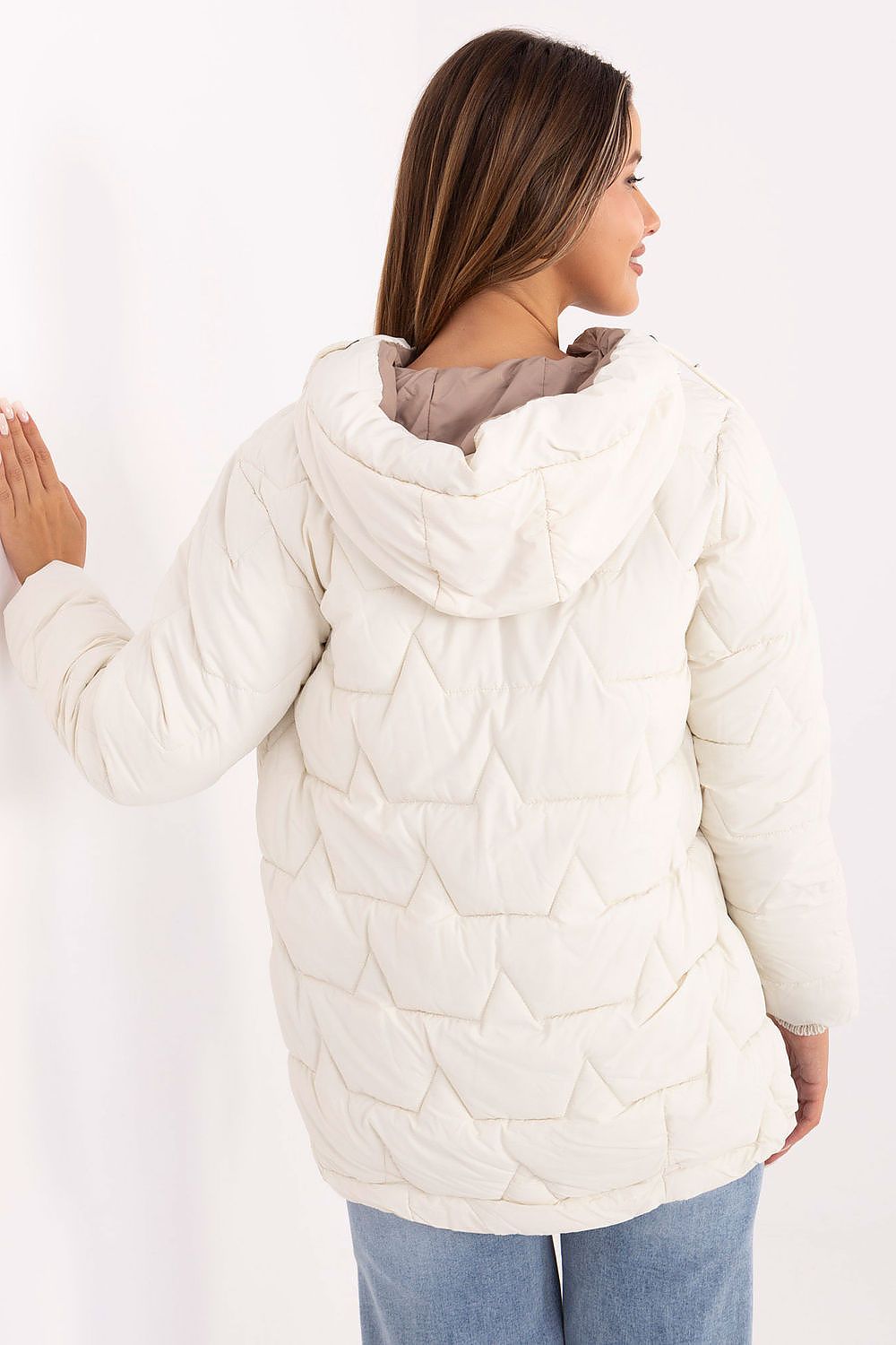 Woman wearing a white quilted jacket on a white background