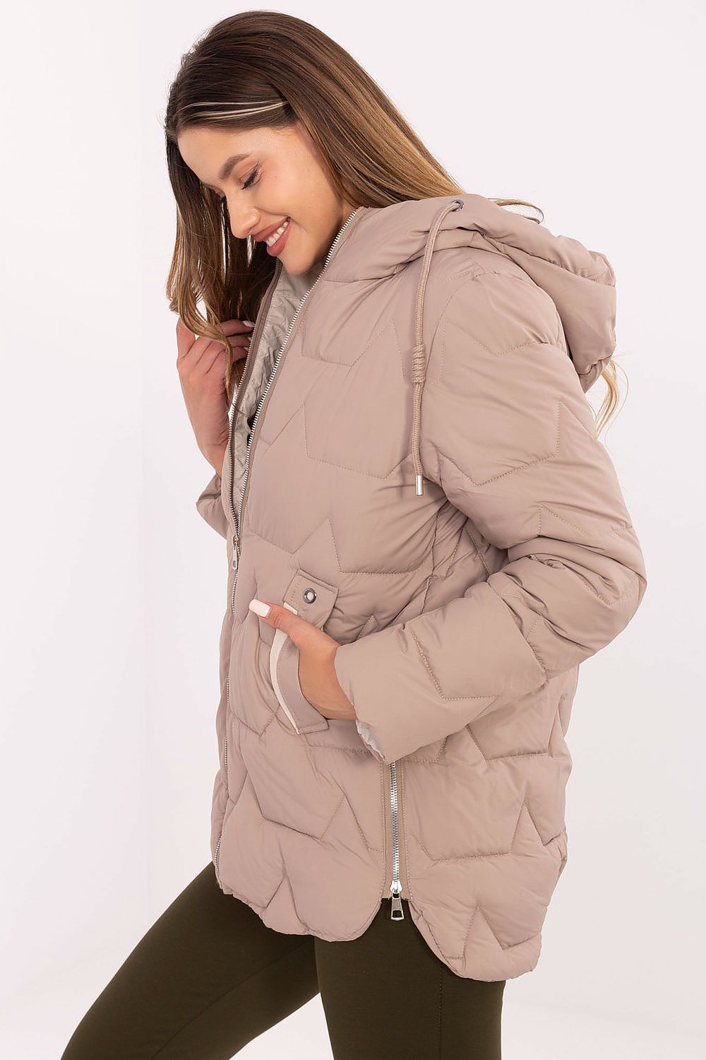Woman wearing a beige puffer jacket on a white background