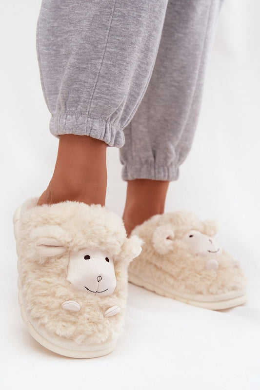 Sheep-themed slippers worn with gray sweatpants on a white background