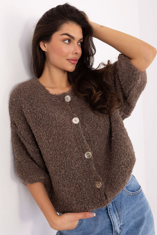 Woman wearing a brown cardigan with buttons against a white background