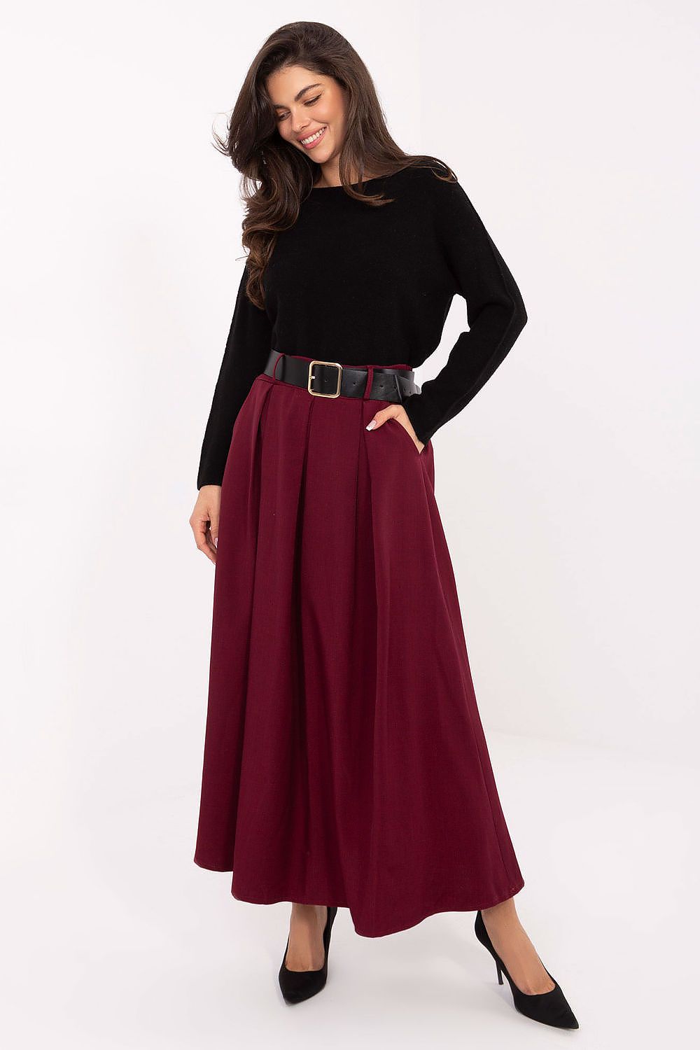 Woman wearing a black top and burgundy skirt on a white background