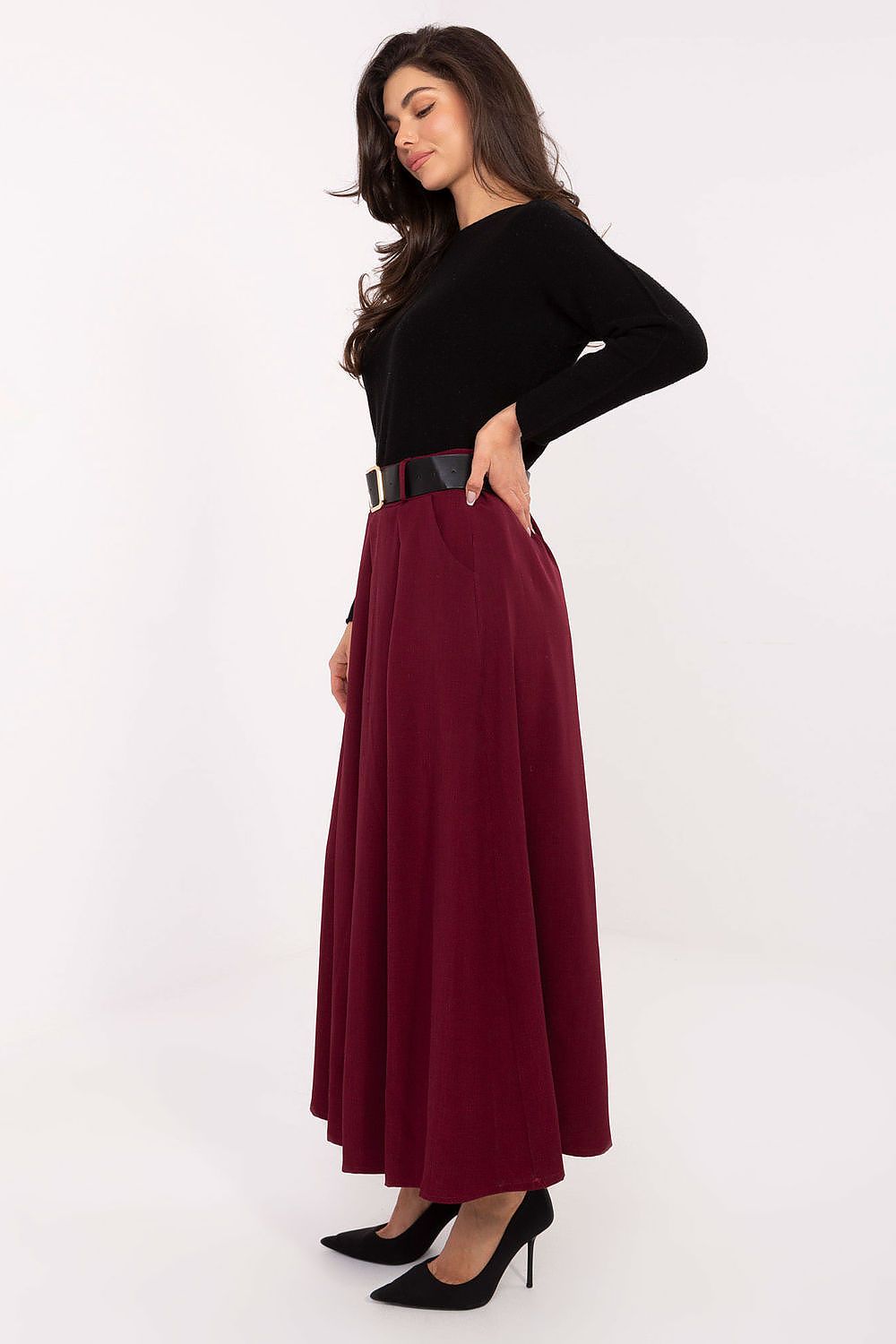 Woman wearing a black top and burgundy skirt on a white background