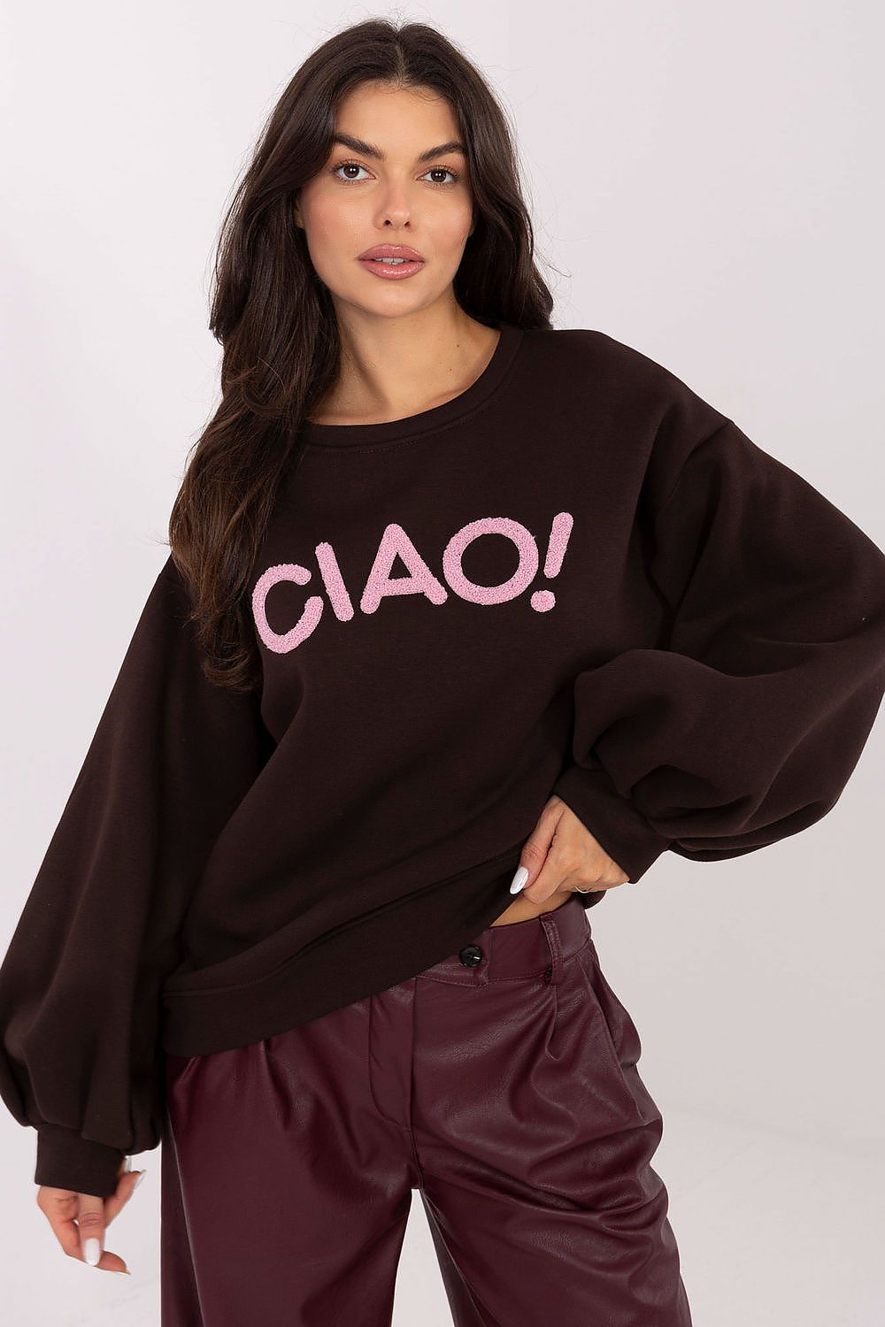 Woman wearing a black sweater with 'CIAO!' in pink on a white background