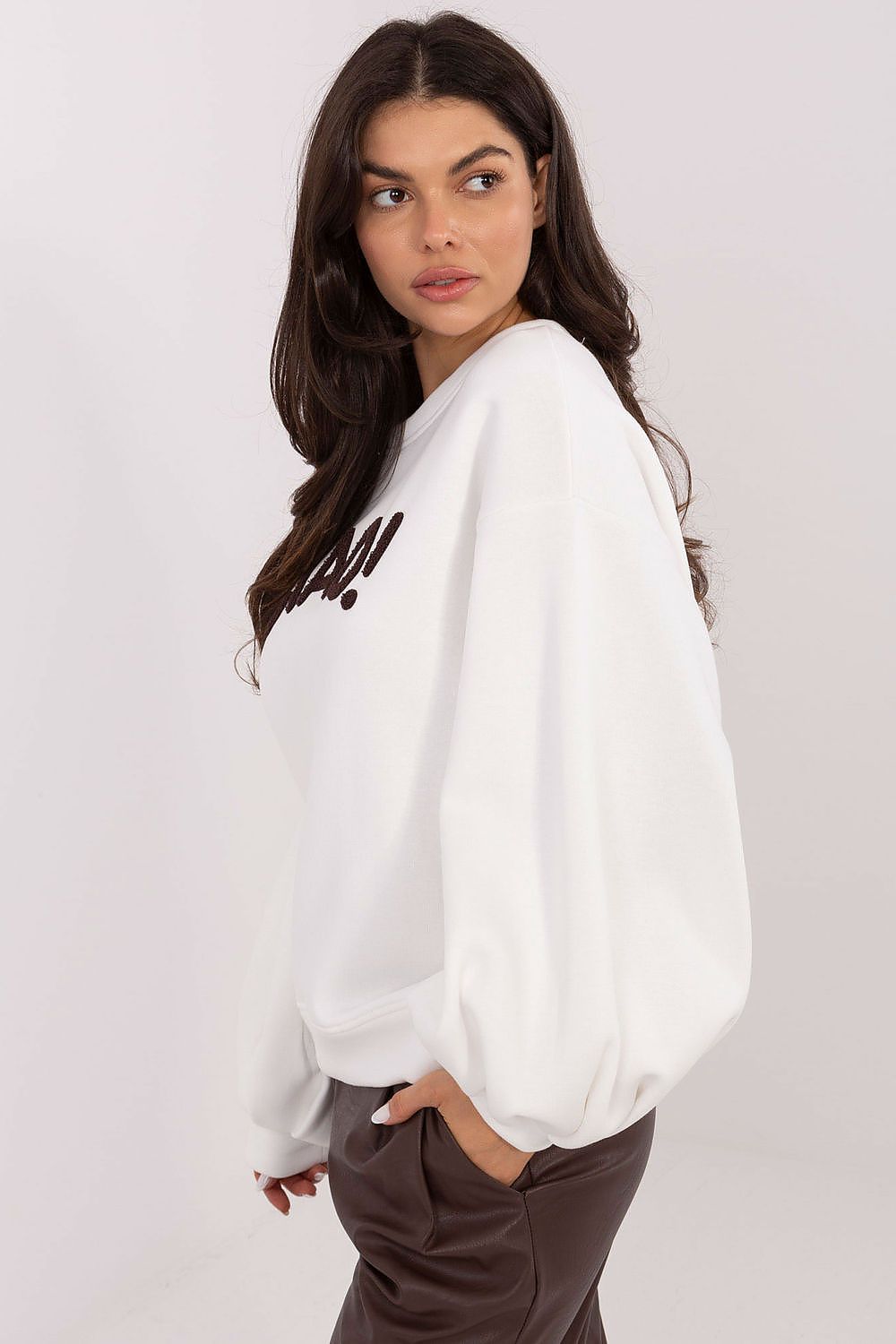 Woman wearing a white sweatshirt with text on a plain background