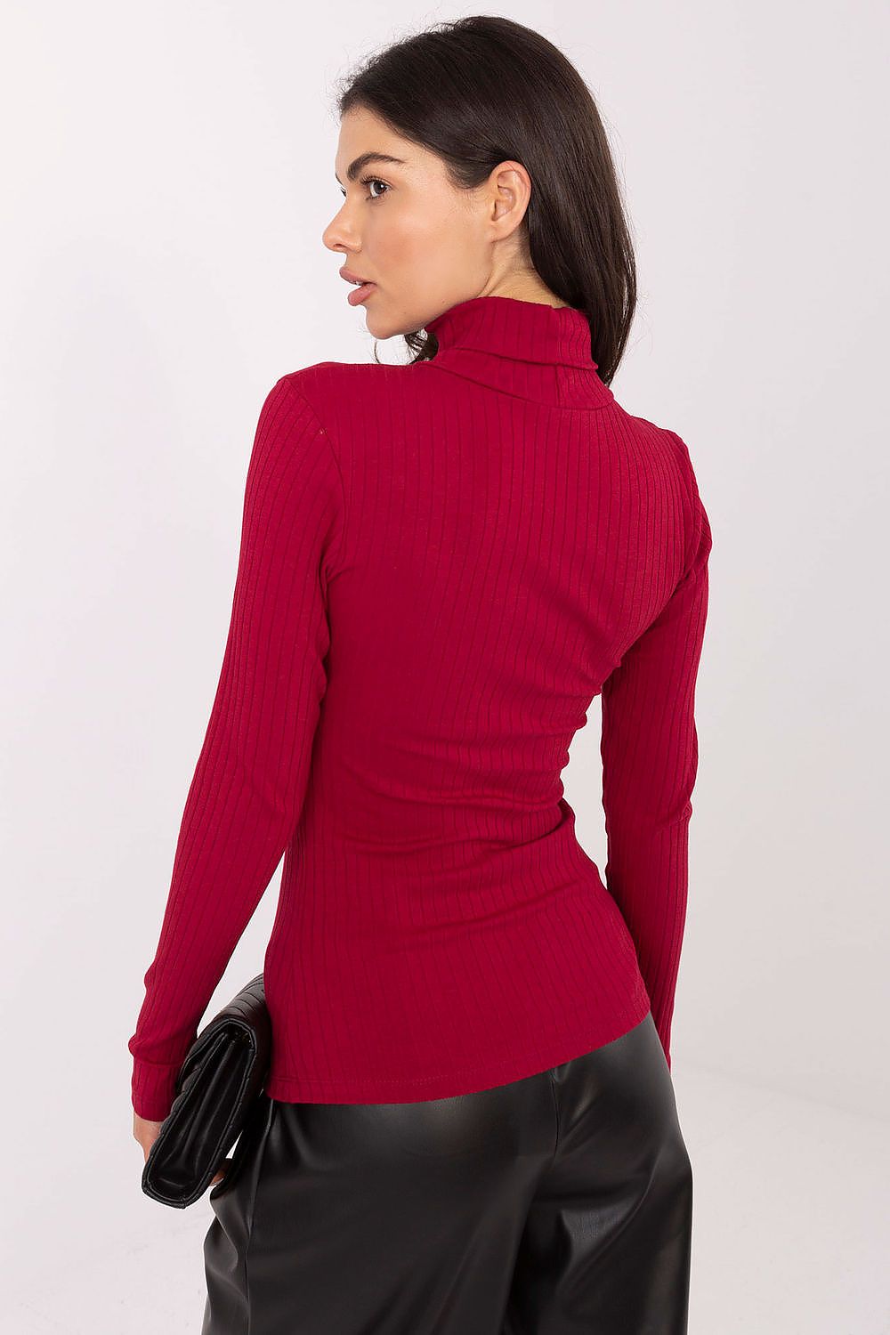 Woman wearing a red ribbed sweater against a white background