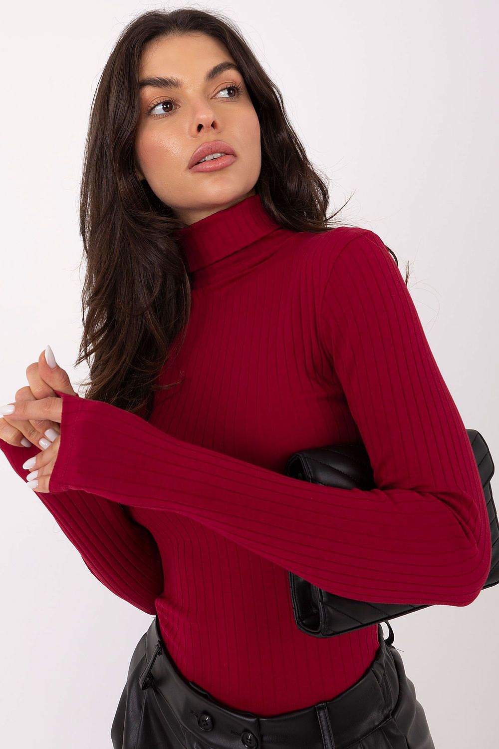 Woman wearing a red turtleneck sweater against a white background