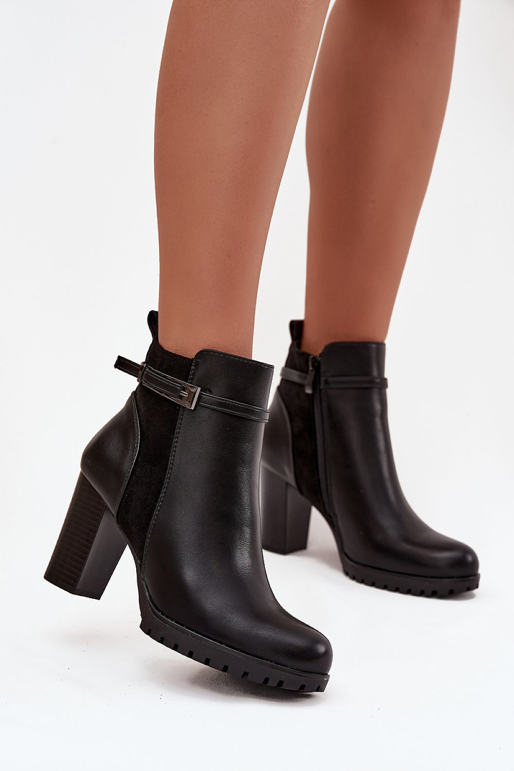 Black ankle boots with block heels on a white background