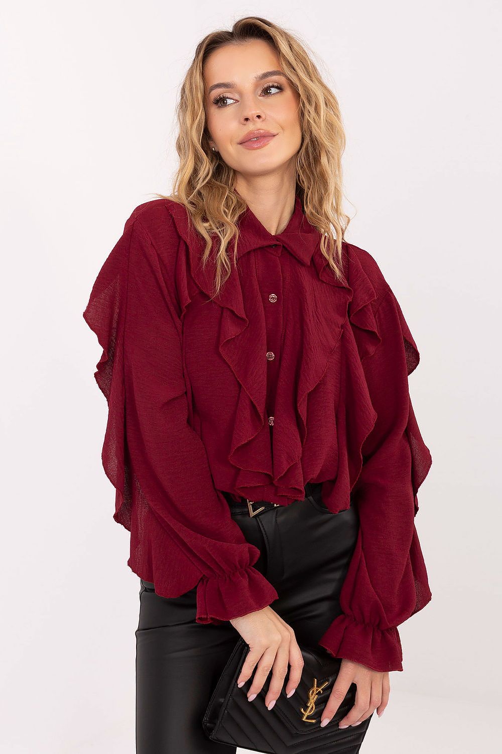 Woman wearing a burgundy ruffled blouse on a white background