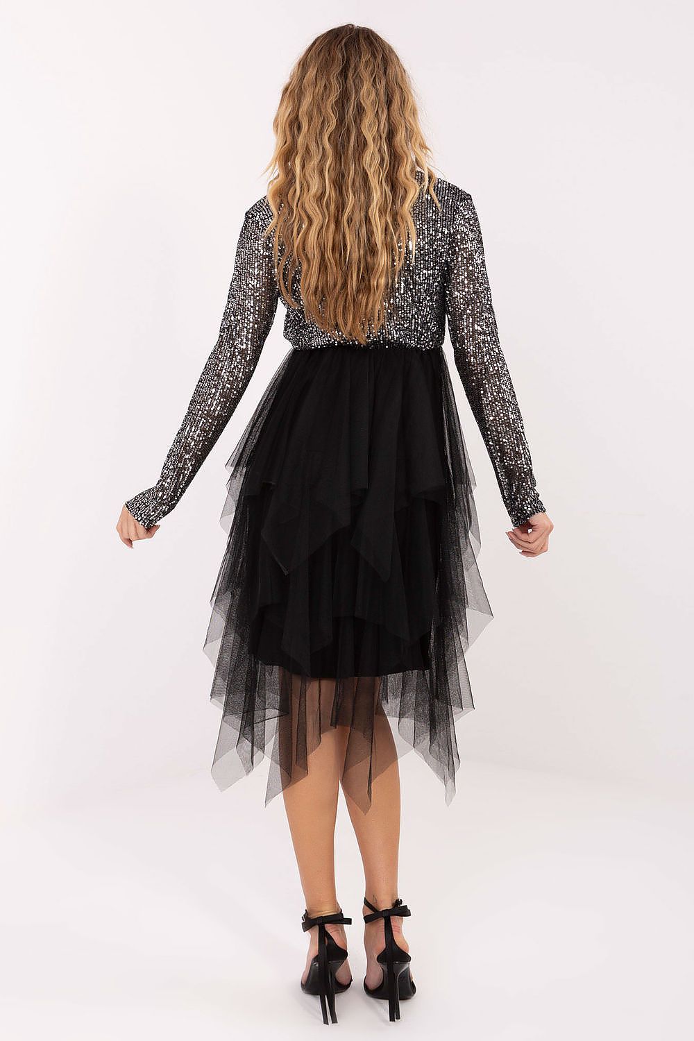 Woman wearing a black and silver dress with a white background