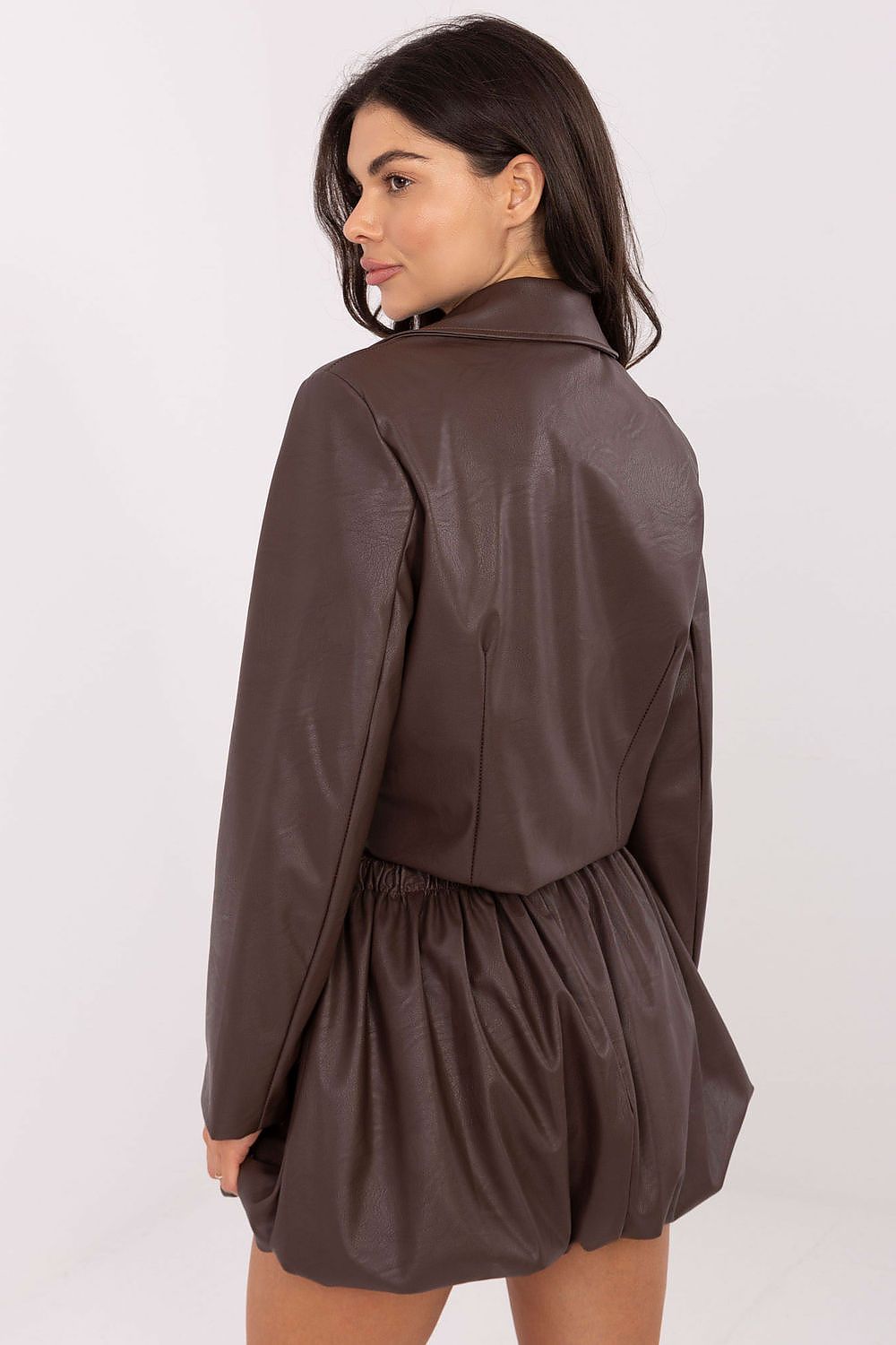 Woman wearing a brown leather jacket and shorts on a white background