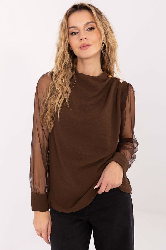 Woman wearing a brown blouse with sheer sleeves on a white background