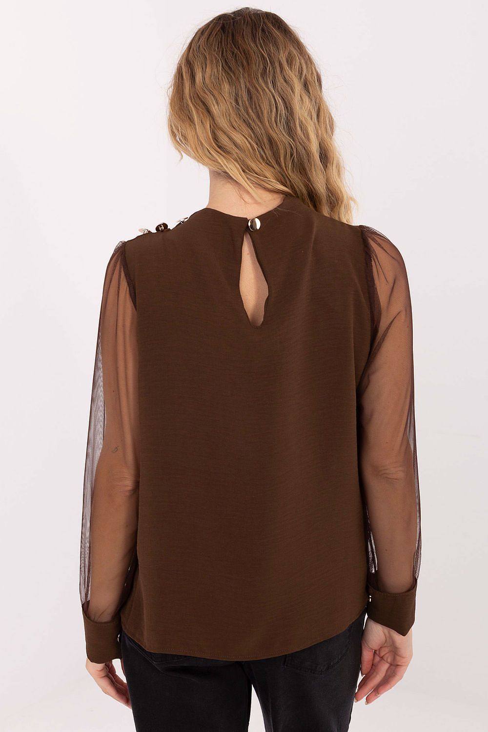 Brown blouse with sheer sleeves worn by a person on a white background
