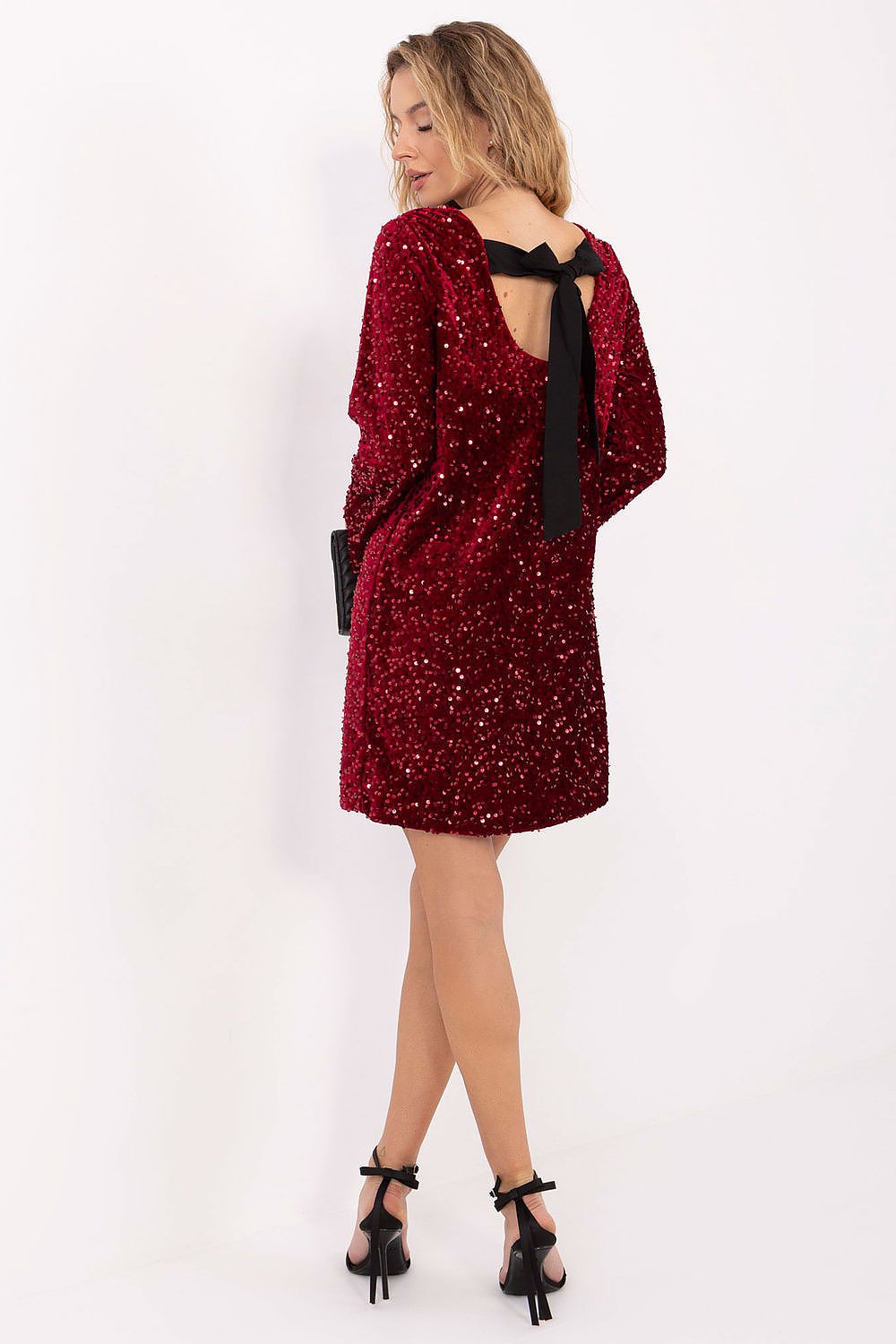 Deep back neckline with oversized bow detail on sequin dress. 