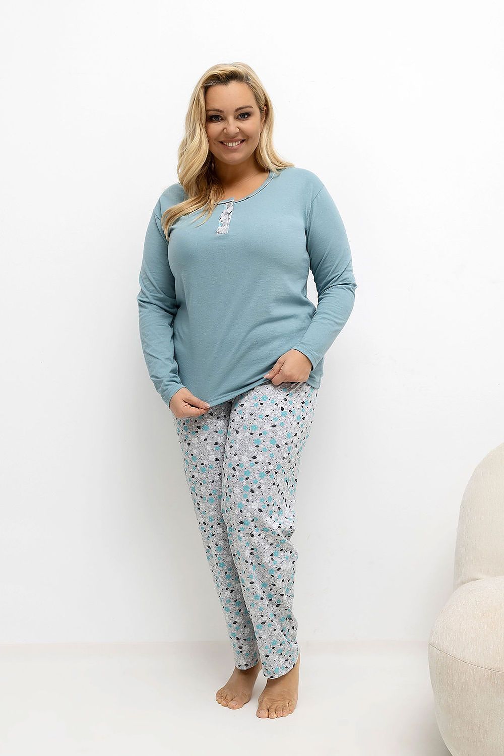 Woman wearing a blue pajama set with a white background