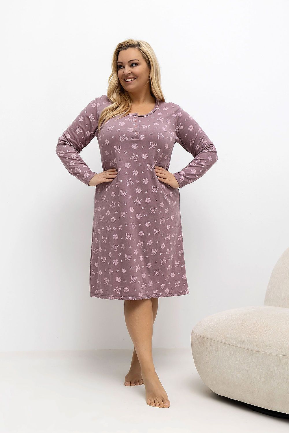 Woman wearing a purple floral nightgown on a white background